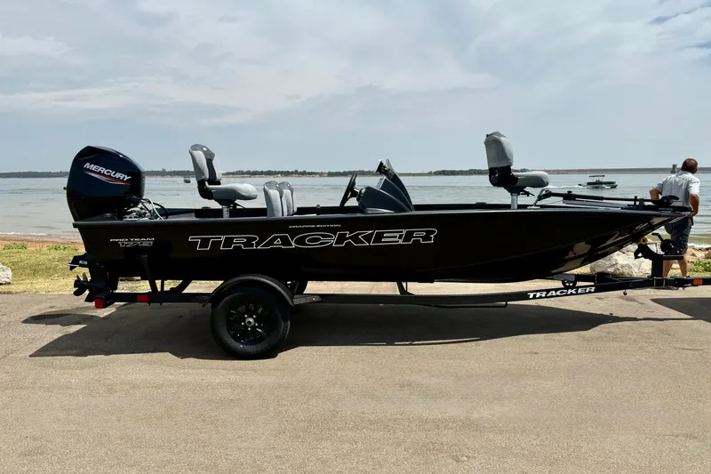 The Image of 2027 Tracker Pro Team 175 Crappie Edition boat on trailer by a lake. - 0