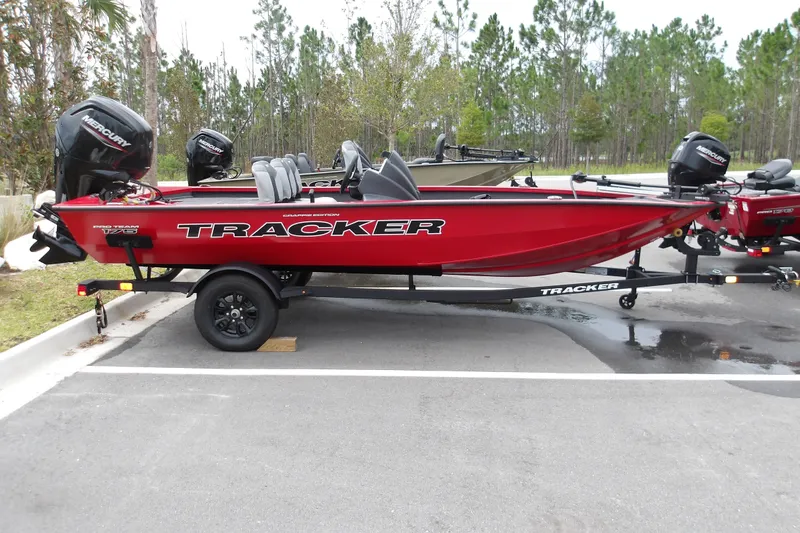 The Image of 2027 Tracker Pro Team 175 Crappie Edition boat, red, parked on trailer in outdoor setting. - 1
