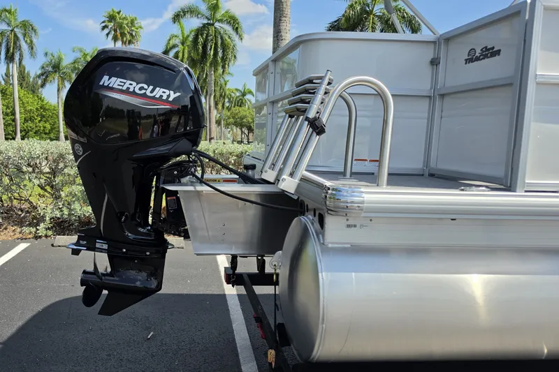 Slide: The Image of 2027 Sun Tracker Party Barge 18 DLX with Mercury outboard motor, parked near palm trees. - 16