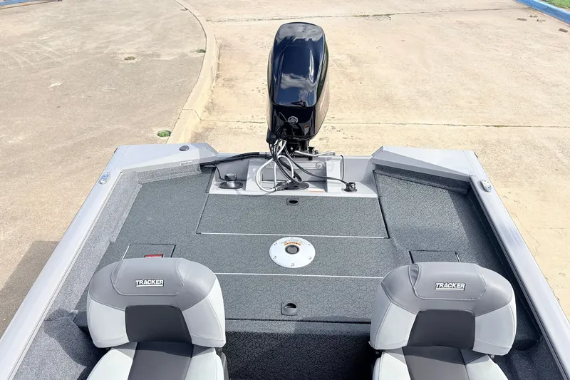Slide: The Image of 2027 Tracker Pro Team 175 Crappie Edition boat with dual seats and motor, docked on concrete. - 28