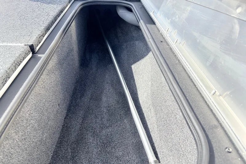 Slide: The Image of Storage compartment of 2027 Tracker Pro Team 175 Crappie Edition boat, featuring carpeted interior. - 17