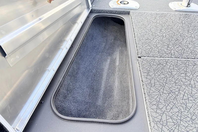 Slide: The Image of 2027 Tracker Pro Team 175 Crappie Edition boat storage compartment with textured flooring. - 14