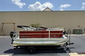 The Image of 2027 Sun Tracker Party Barge 16 DLX pontoon boat on trailer, parked outdoors. - 0