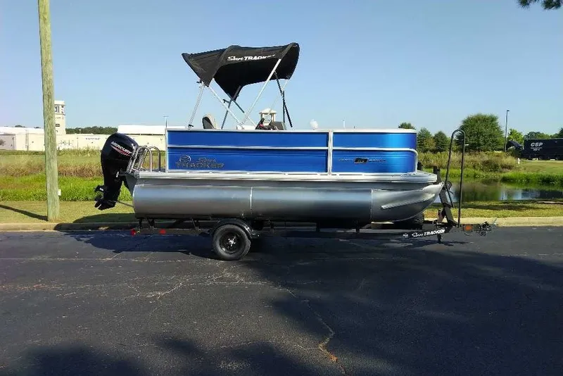 The Image of 2027 Sun Tracker Party Barge 16 DLX pontoon boat on trailer, parked outdoors. - 0