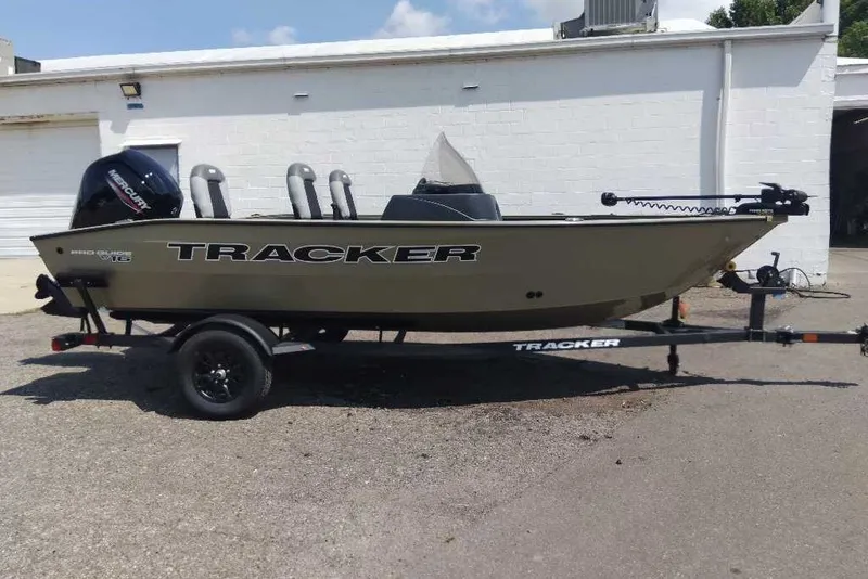 The Image of 2027 Tracker Pro Guide V-16 SC boat on trailer, parked outdoors. - 0