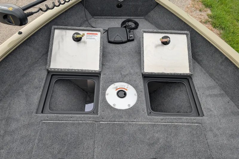 Slide: The Image of 2027 Tracker Pro Guide V-16 SC boat interior with storage compartments and carpeted flooring. - 55