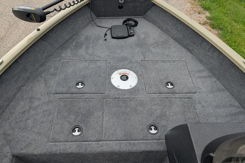Slide: The Image of Interior view of 2027 Tracker Pro Guide V-16 SC boat with carpeted deck and storage compartments. - 53