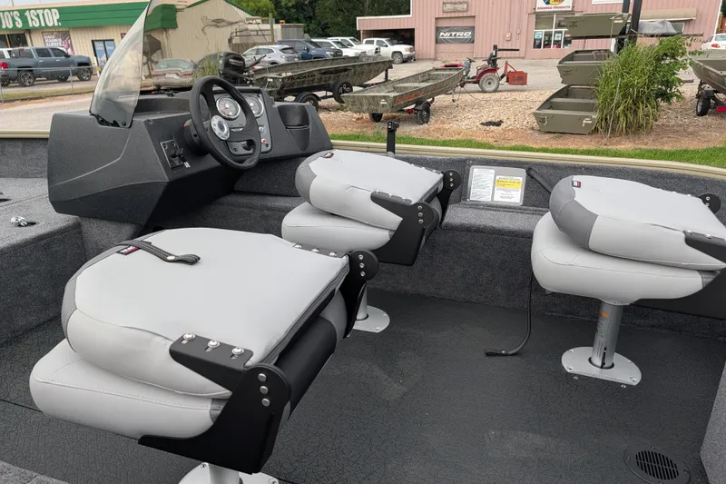 Slide: The Image of 2027 Tracker Pro Guide V-16 SC boat interior with steering console and cushioned seats. - 47