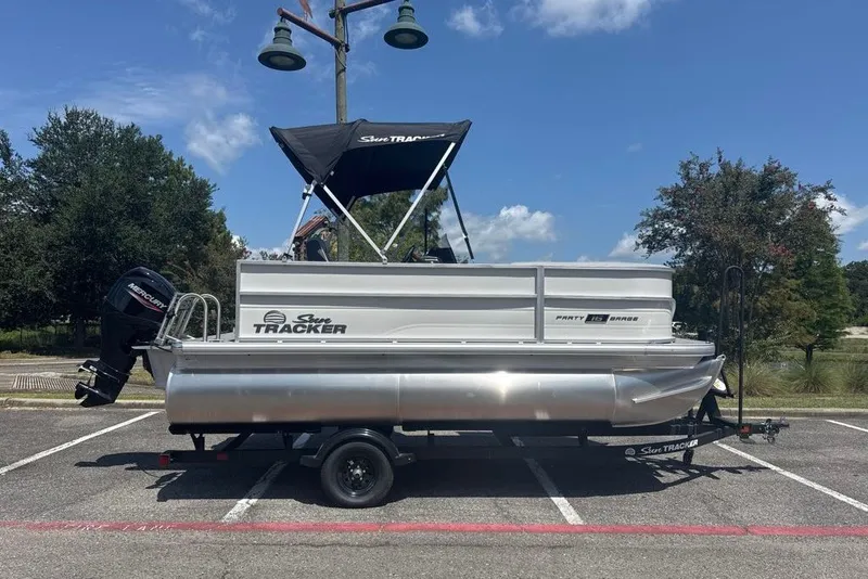 The Image of 2027 Sun Tracker Party Barge 16 DLX pontoon boat parked outdoors. - 0