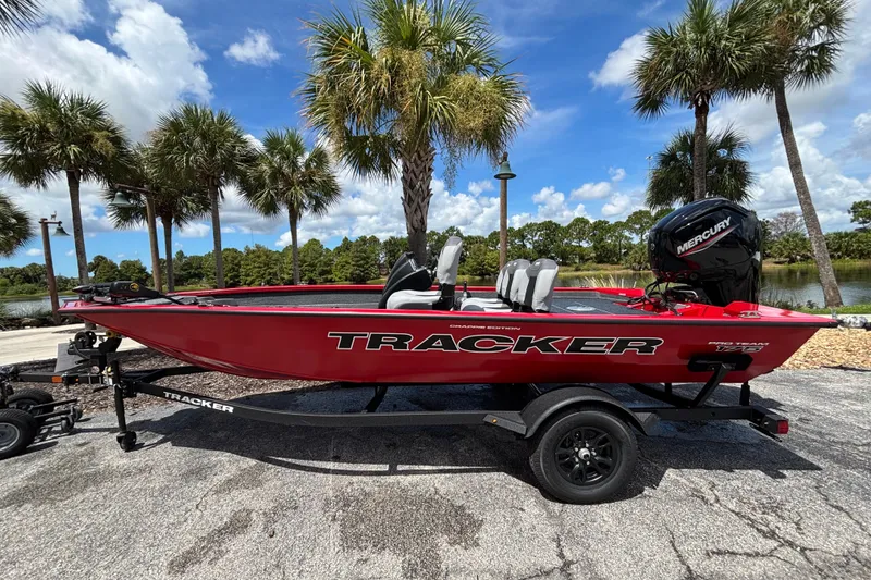The Image of 2027 Tracker Pro Team 175 Crappie Edition boat on trailer, palm trees background. - 0