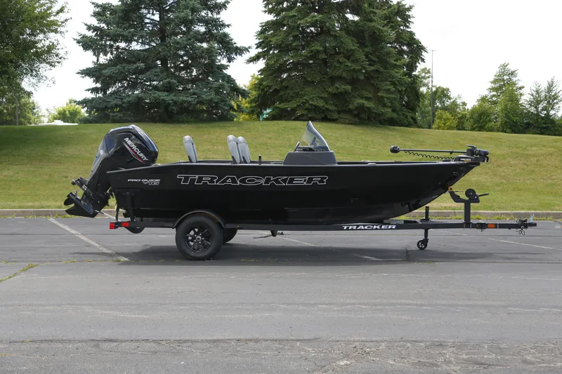 The Image of 2027 Tracker Pro Guide V-16 SC boat on trailer, parked outdoors. - 0