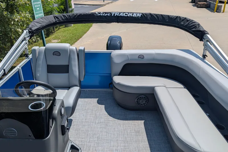 Slide: The Image of 2027 Sun Tracker Party Barge 16 DLX interior with gray seating and steering console. - 14