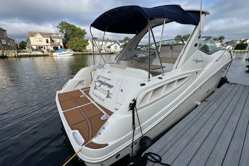Slide: The Image of 2008 Sea Ray Sundancer 310 docked, featuring sleek design and spacious deck area. - 6