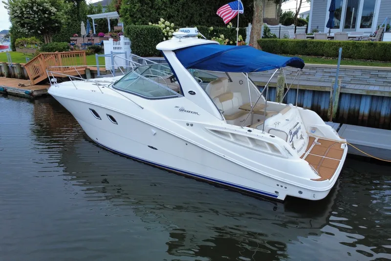 Slide: The Image of 2008 Sea Ray Sundancer 310 docked, featuring sleek design and blue canopy. - 3