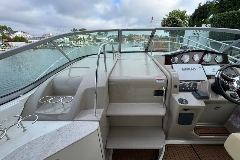 Slide: The Image of 2008 Sea Ray Sundancer 310 cockpit with steering wheel, control panel, and cup holders. - 17