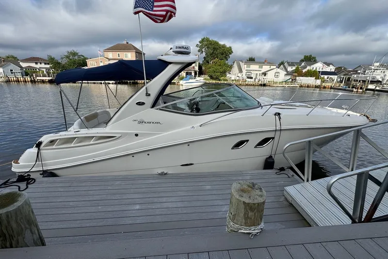 Slide: The Image of 2008 Sea Ray Sundancer 310 docked by waterfront homes under cloudy sky. - 4