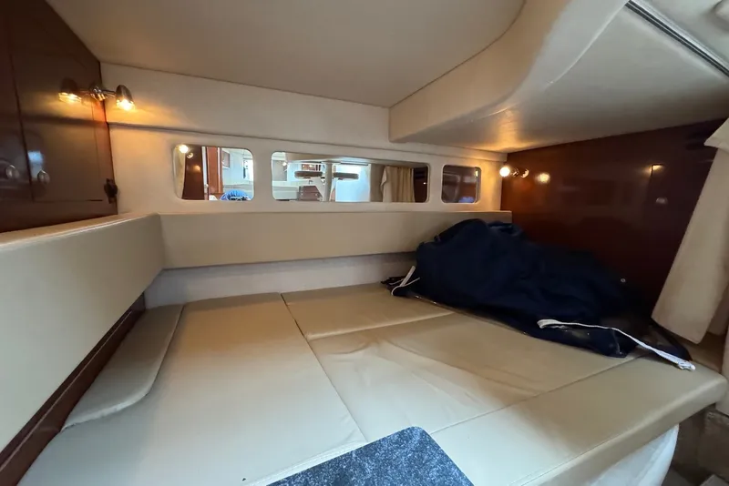 Slide: The Image of 2008 Sea Ray Sundancer 310 cabin interior with beige seating and ambient lighting. - 24