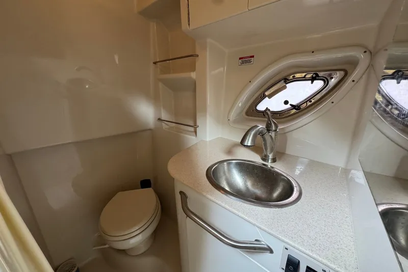 Slide: The Image of 2008 Sea Ray Sundancer 310 bathroom with sink, toilet, and porthole window. - 23