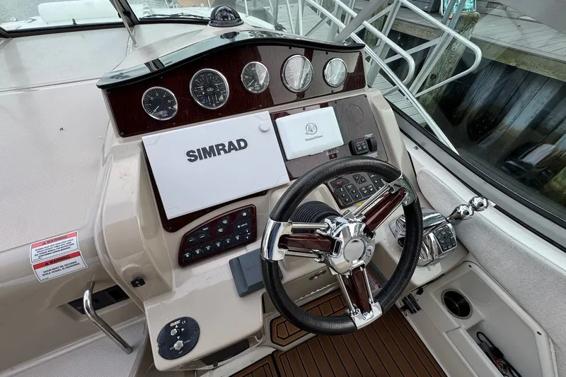 Slide: The Image of 2008 Sea Ray Sundancer 310 helm with Simrad navigation system and polished steering wheel. - 16