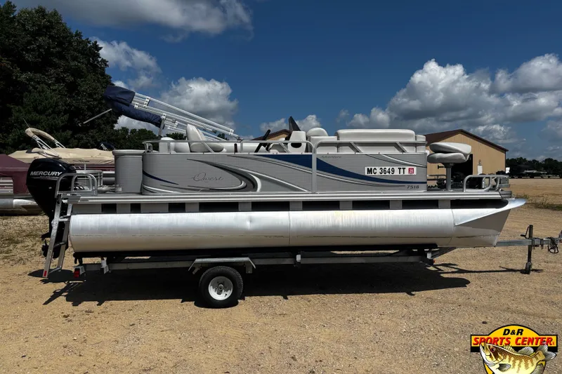 Slide: The Image of 2015 Qwest Adventure 7518 Sport Cruise pontoon boat on trailer, outdoor setting. - 2