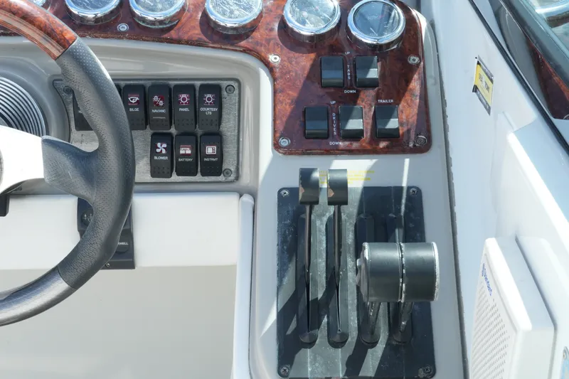 Slide: The Image of Dashboard controls of a 2004 Formula 330 Sun Sport boat, featuring steering wheel and switches. - 26