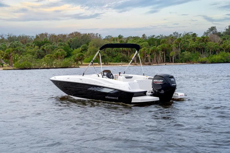 The Image of 2027 Bayliner Element E18 boat on a scenic lake with lush greenery. - 1