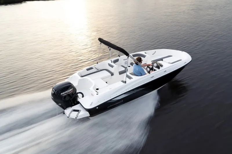 Slide: The Image of 2027 Bayliner Element E18 boat cruising on calm water at sunset. - 2
