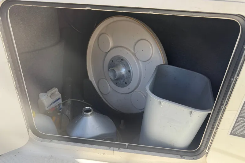 Slide: The Image of Storage compartment of a 2006 Sea Ray 240 Sundeck with various items inside. - 30