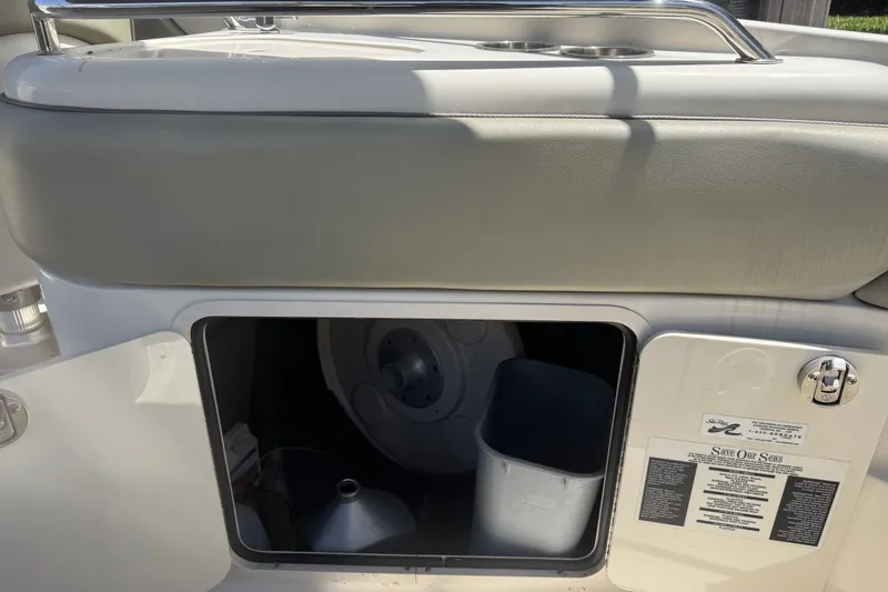Slide: The Image of Storage compartment on a 2006 Sea Ray 240 Sundeck boat, featuring a bucket and safety instructions. - 31