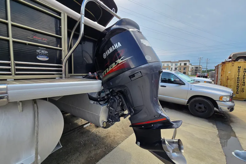 Slide: The Image of 2013 Sanpan 2500 FE pontoon boat with Yamaha outboard motor in a parking lot. - 7