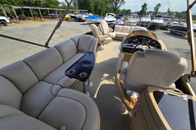 Slide: The Image of 2013 Sanpan 2500 FE pontoon boat interior with beige seating and steering console. - 22