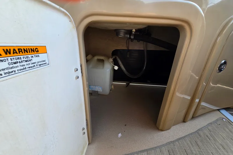 Slide: The Image of Storage compartment of 2013 Sanpan 2500 FE with warning label and container. - 49