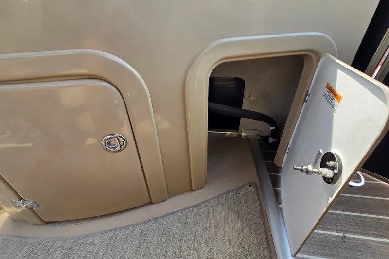 Slide: The Image of Open storage compartment on a 2013 Sanpan 2500 FE boat, showing interior details. - 51