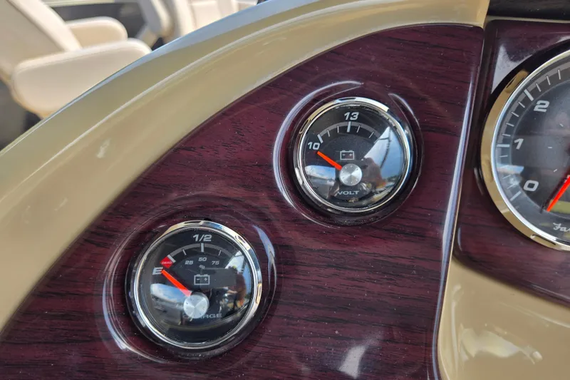 Slide: The Image of Dashboard gauges of a 2013 Sanpan 2500 FE boat, featuring volt and charge indicators. - 32