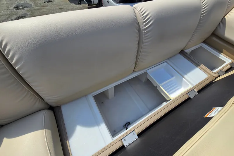 Slide: The Image of 2013 Sanpan 2500 FE boat seat storage compartment with beige upholstery. - 26