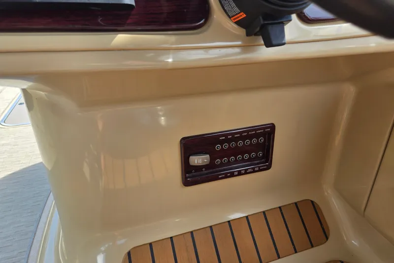 Slide: The Image of Control panel of a 2013 Sanpan 2500 FE boat with wood accents and switches. - 42