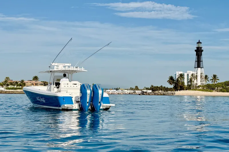Slide: The Image of 2016 Intrepid 375 Center Console boat near a lighthouse on calm waters. - 45