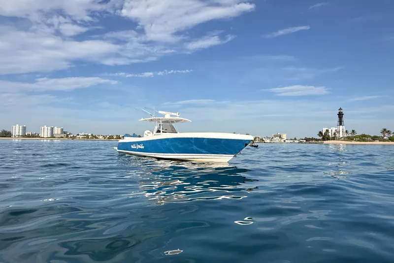Slide: The Image of 2016 Intrepid 375 Center Console boat on calm ocean near a lighthouse. - 40
