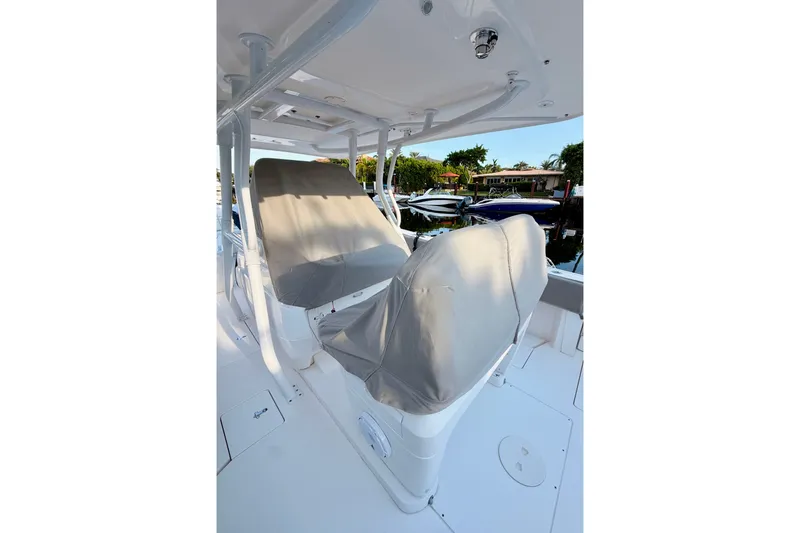 Slide: The Image of 2016 Intrepid 375 Center Console boat with covered seats, docked near waterfront homes. - 4