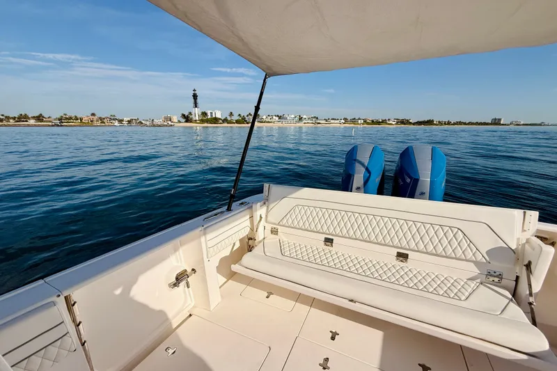 Slide: The Image of 2016 Intrepid 375 Center Console boat with dual engines, coastal view, and lighthouse in the background. - 57