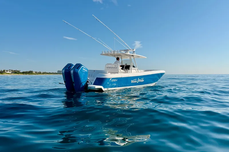 Slide: The Image of 2016 Intrepid 375 Center Console boat on calm ocean waters under clear blue sky. - 42