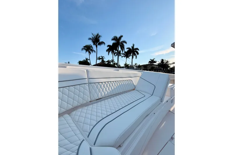 Slide: The Image of Luxurious seating on a 2016 Intrepid 375 Center Console boat with palm trees in the background. - 11