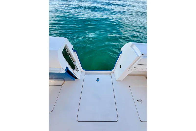 Slide: The Image of 2016 Intrepid 375 Center Console boat deck with open transom, overlooking clear blue water. - 74