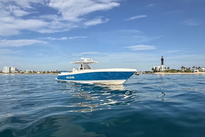 Slide: The Image of 2016 Intrepid 375 Center Console boat on calm ocean near a lighthouse. - 41