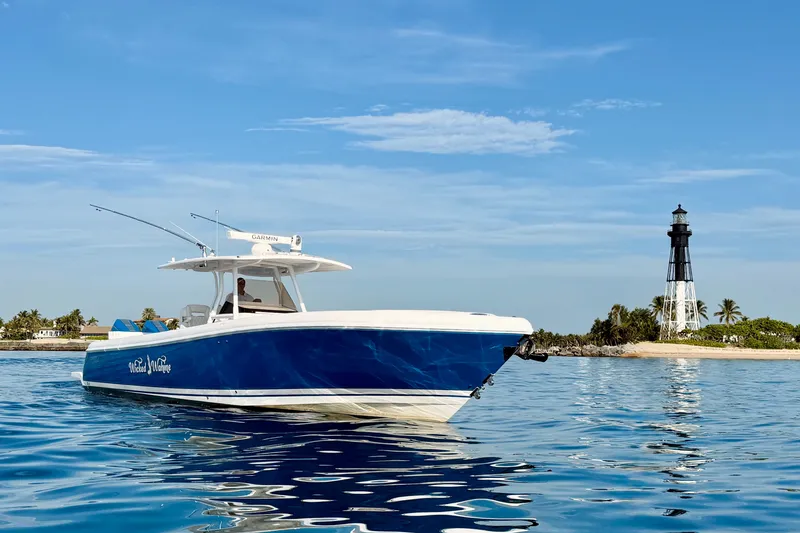 Slide: The Image of 2016 Intrepid 375 Center Console boat near a lighthouse on calm waters. - 34