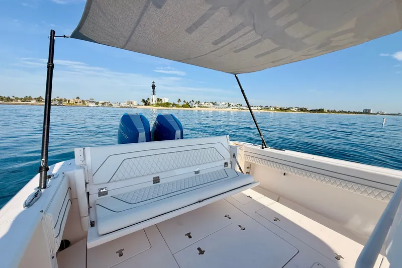 Slide: The Image of 2016 Intrepid 375 Center Console boat with dual engines, coastal view, and shaded seating area. - 59