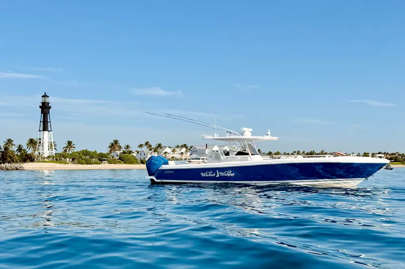 Slide: The Image of 2016 Intrepid 375 Center Console boat near a lighthouse and palm-lined shore. - 38