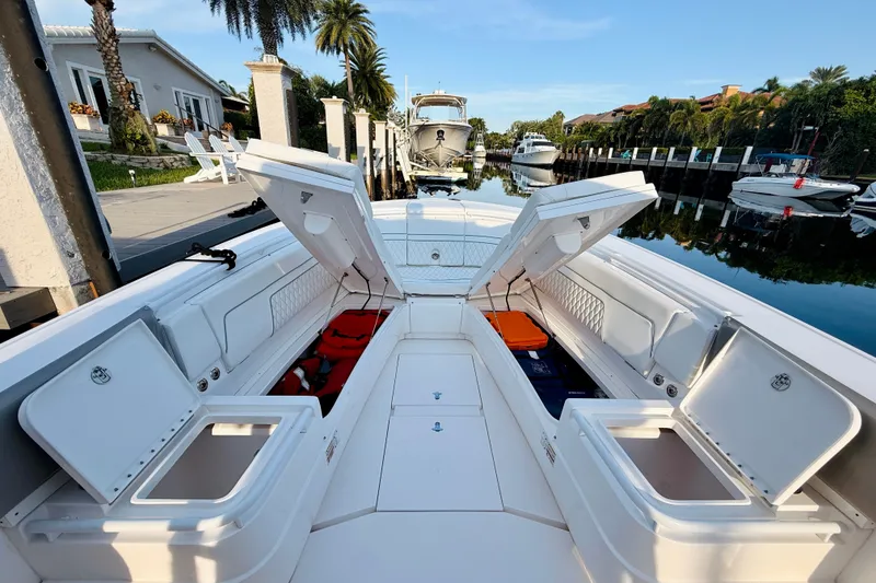Slide: The Image of 2016 Intrepid 375 Center Console boat with open storage compartments, docked by waterfront homes. - 9