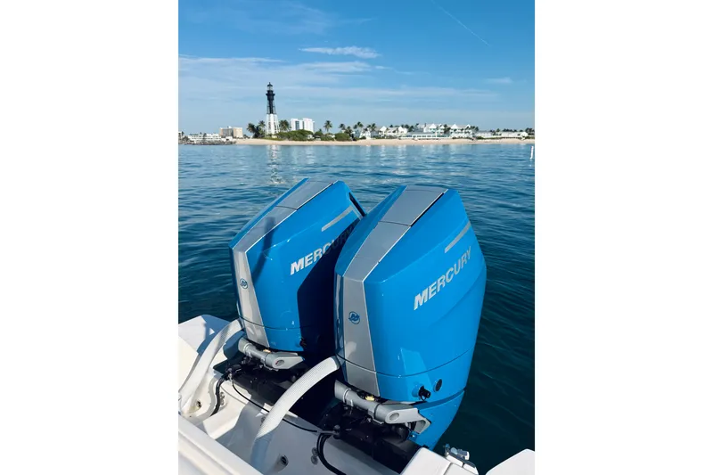 Slide: The Image of Twin Mercury outboard engines on a 2016 Intrepid 375 Center Console, with coastal view. - 70
