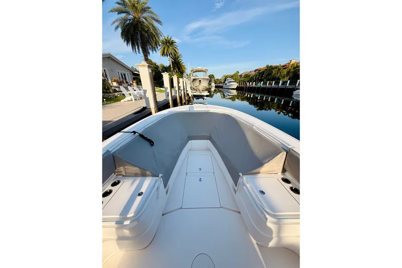 Slide: The Image of 2016 Intrepid 375 Center Console boat docked by palm trees and waterfront homes. - 1